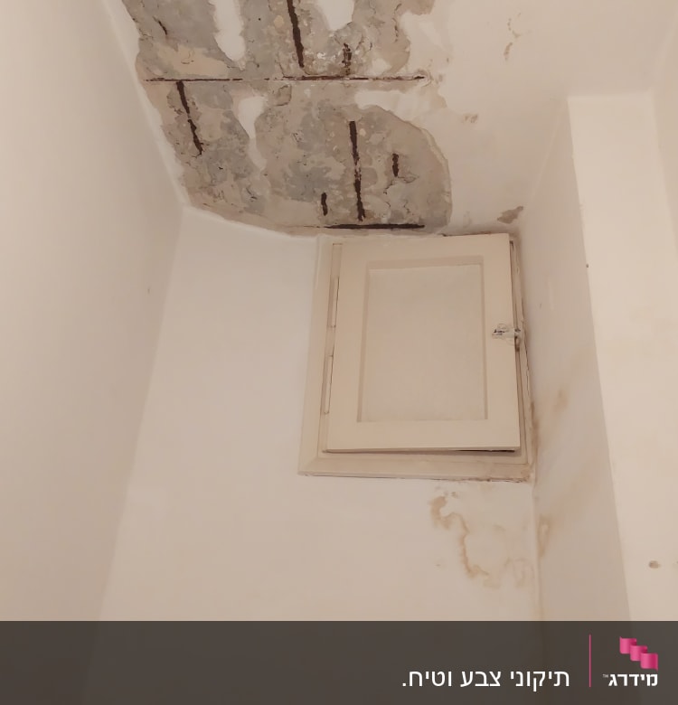 תקרה מתקלפת עם סימני רטיבות וקיר לבן